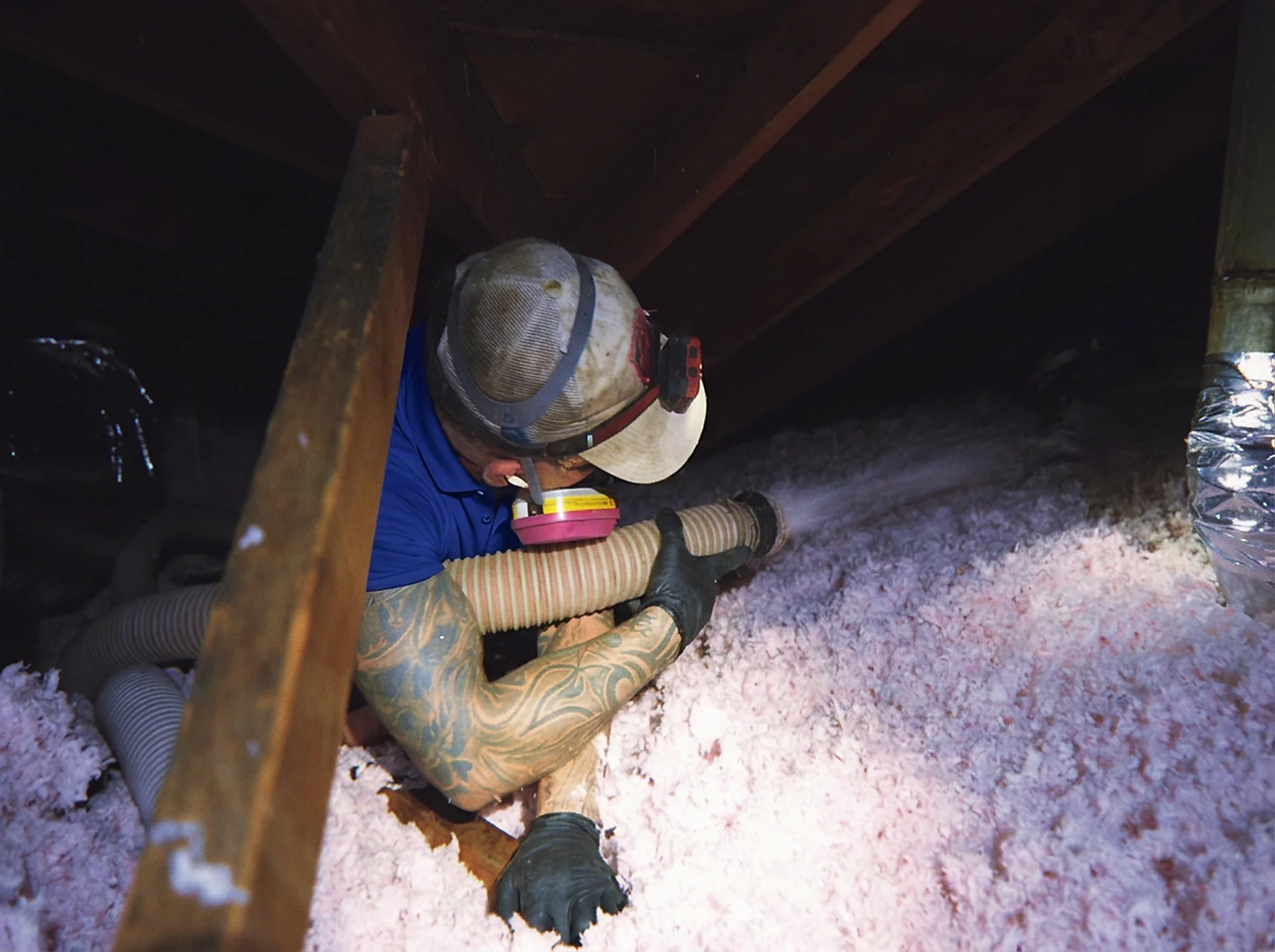 Green Faith Solutions installer distributing insulation around attic framing